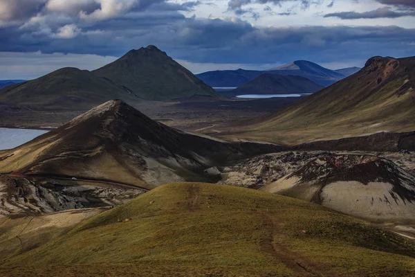 Maravilhosa paisagem icelânica. terra da grama, lago, montanhas multicoloridas altas, e céu bonito — Fotografia de Stock