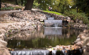 Zor bir günün ardından dinlenmek ve dinlenmek için parkta küçük bir şelale.