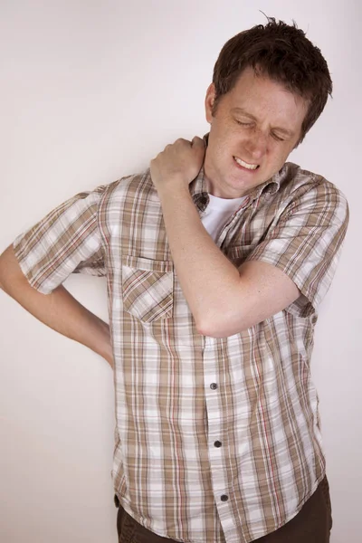 Man cringing from shoulder pain — Stock Photo, Image