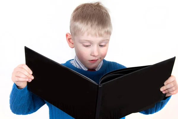 Молодий хлопчик читає велику книгу — стокове фото