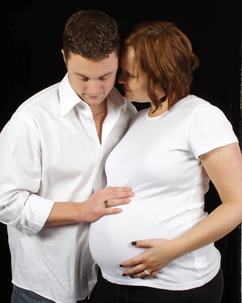 Беременная женщина любовно смотрит на мужа — стоковое фото