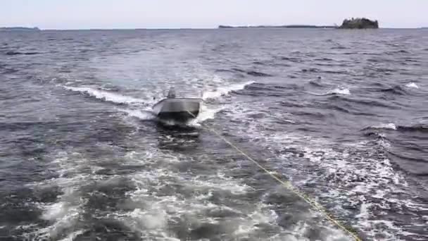 Um pequeno barco a ser rebocado no oceano — Vídeo de Stock