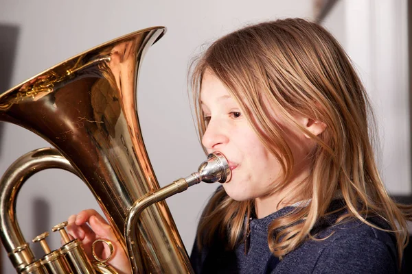 Ung flicka blåser horn — Stockfoto