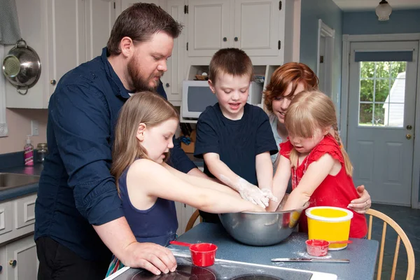 Семья, работающая вместе дома на кухне — стоковое фото