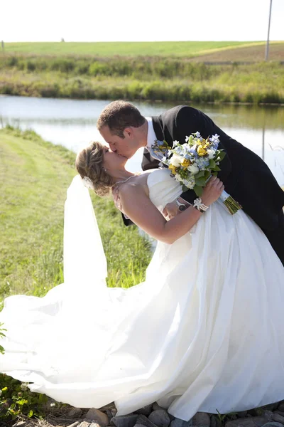Nygifte danser og kysser - Stock-foto