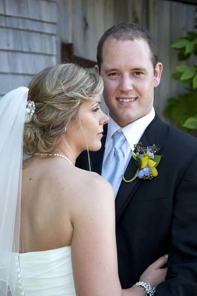 Na fotoaparát s opodál nevěsta ženich usmívá — Stock fotografie