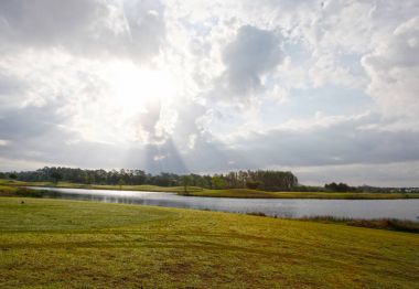 cloudy sun and sky on golf course clipart