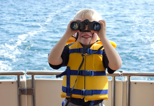 A boy with binoculars looking at you — Stock Photo, Image