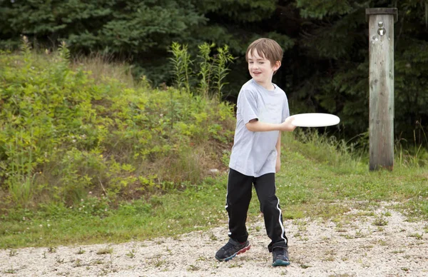 Little boy on a dirt road with frisbee — Stock Photo, Image