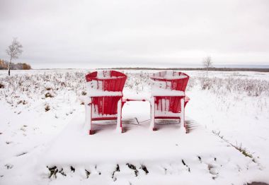 iki kırmızı Adirondack sandalye karlı alanda 