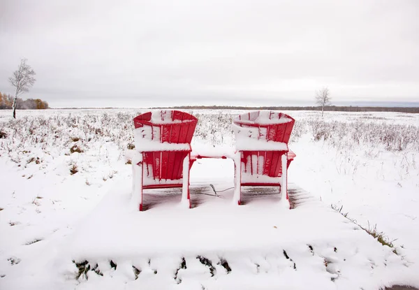 iki kırmızı Adirondack sandalye karlı alanda 