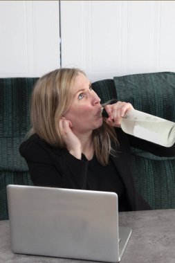 woman on her laptop with a big bottle of booze clipart