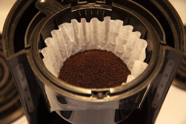 a paper filter is full of fresh coffee grinds ready for brewing