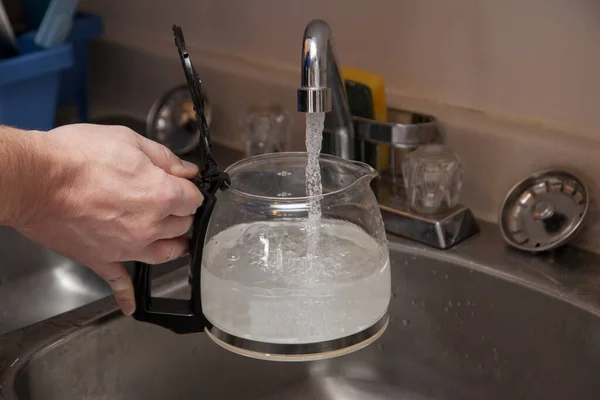 Befüllen Der Gläsernen Kaffeekanne Mit Wasser Der Spüle Stockfoto