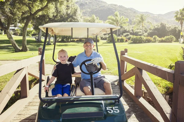 Отец и сын играют вместе в гольф в летний день — стоковое фото