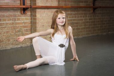 Beautiful young and talented dancer posing at a dance studio. Full length photo of a cute ballerina with copy space clipart