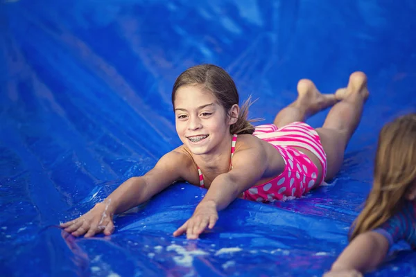 Meisje glijdend van een slip en glijbaan — Stockfoto