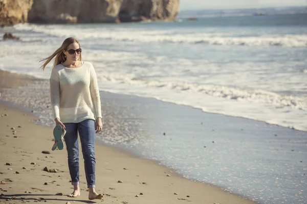 Mujer caminando sola por una playa tranquila pensando y reflexionando — Foto de Stock