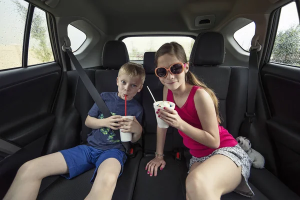 Kinderen eten een traktatie in de achterkant van hun auto — Stockfoto