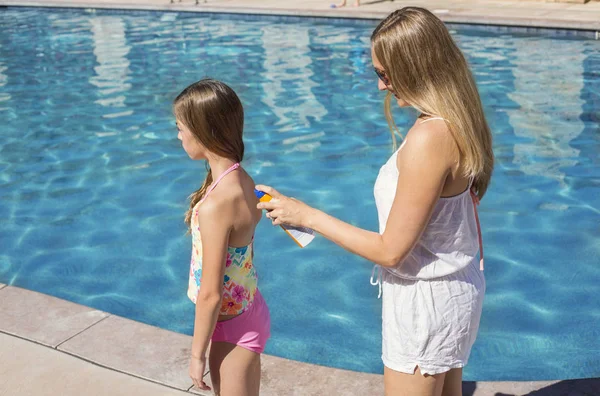 Anne küçük kız havuz başında güneş koruyucu uygulamak — Stok fotoğraf