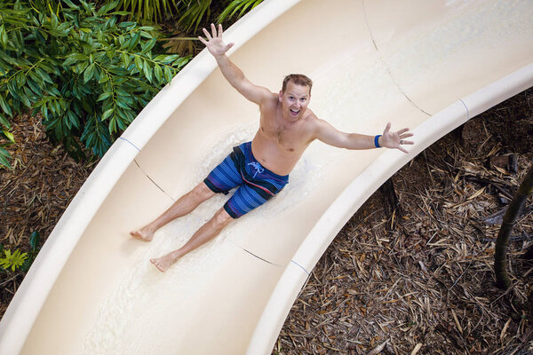 Сползти вниз по водной горке в аквапарке
