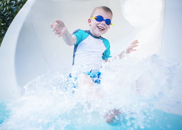 Boy sliding down a slip and slide — Stock Photo, Image