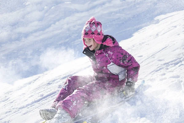 Happy and excited girl Sledding downhill on a snowy day — Stock Photo, Image