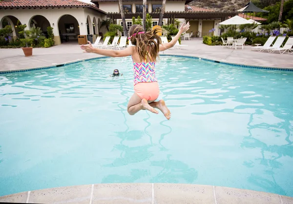 Criança pulando em uma grande piscina — Fotografia de Stock