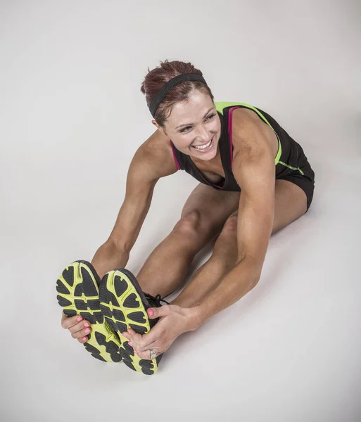 Forte femminile tonica e muscolosa stretching prima del suo allenamento . — Foto Stock