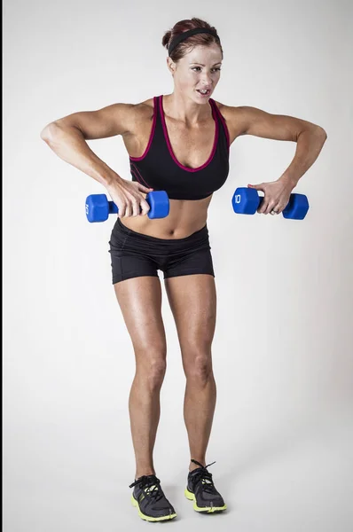 Starke schöne Fitness-Frau beim Hantelheben — Stockfoto