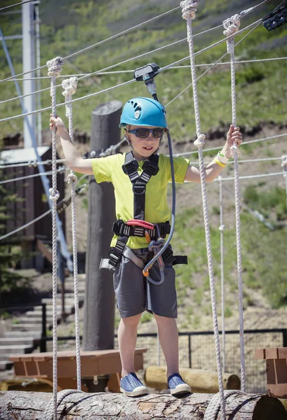 Kleine jongen op een cursus buiten touwen klimmen — Stockfoto