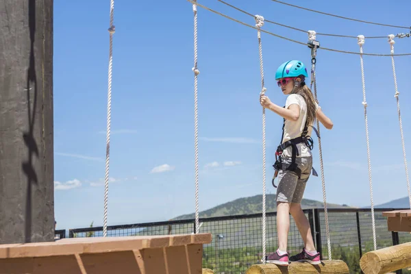 Kislány felmászni egy szabadtéri kötélpálya — Stock Fotó