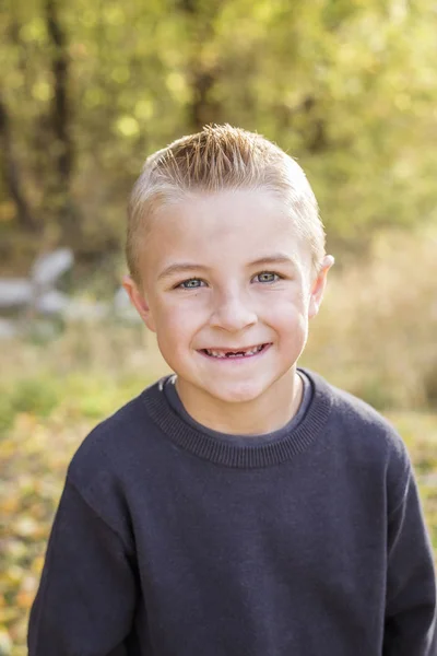 Mignon, souriant, jeune garçon portrait à l'extérieur. Il a un grand sourire édenté. — Photo