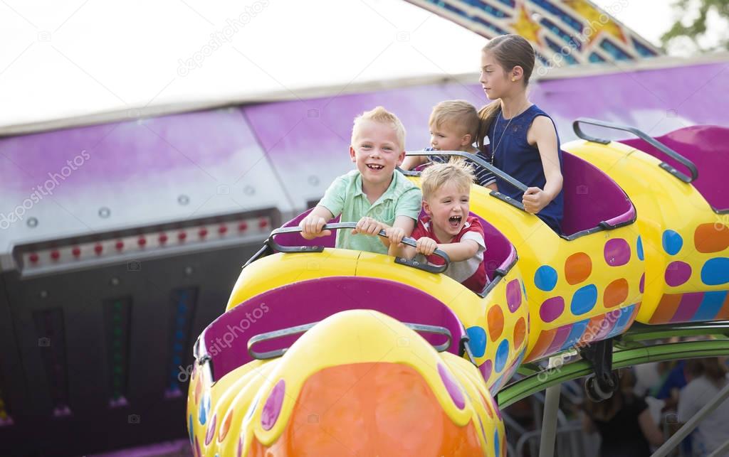 Kids on a thrilling roller coaster ride at an amusement park