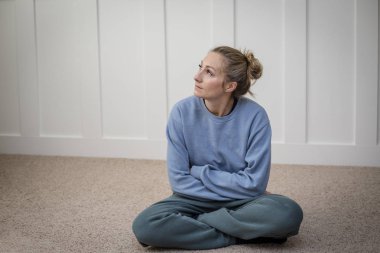 woman deep in thought struggle with depression while attempting to meditate or pray in her home. Abstract photo of a woman contemplating life`s challenges clipart