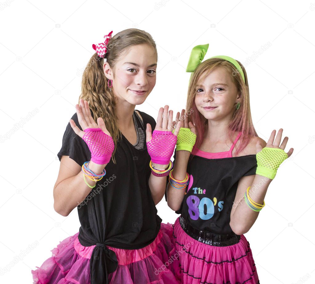 Cute girls dressed in retro 80s decade costumes. Smiling happy girls isolated on a white background playing and posing together