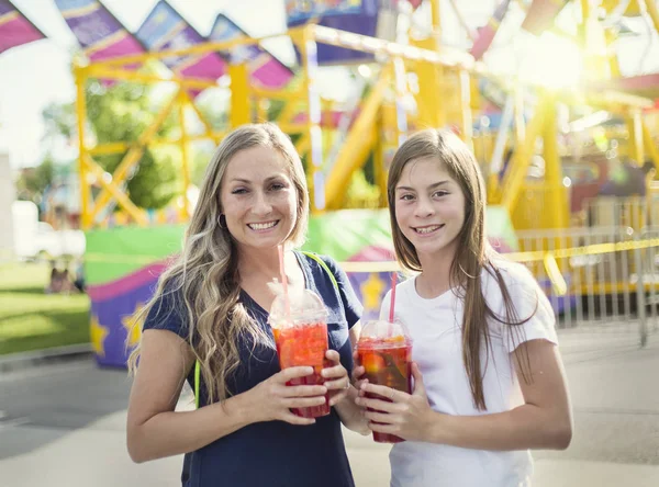 Duas Meninas Felizes Bebendo Uma Bebida Doce Parque Diversões Carnaval — Fotografia de Stock