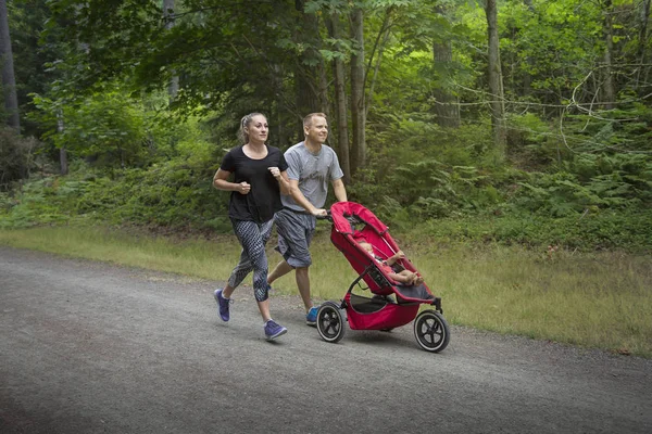 Casal Exercitando Jogging Juntos Empurrando Seu Bebê Carrinho — Fotografia de Stock