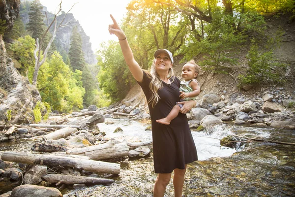 素晴らしい屋外で自然の中で遊んで美しい若い母親と彼女の息子 渓流沿いをハイキングしながら 自然の美しさを指摘している — ストック写真