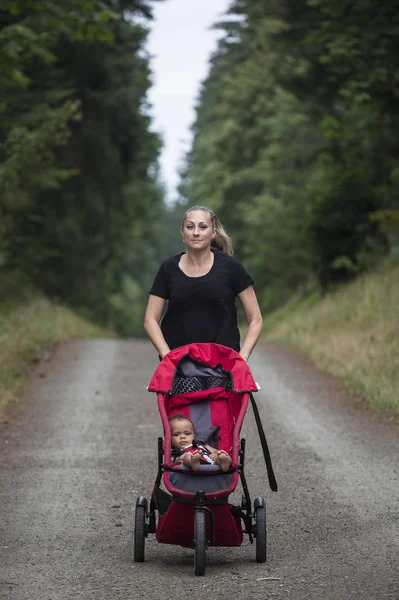 Attractive Woman Running Trail Pushing Her Baby Stroller Outdoors Vertical — Stock Photo, Image