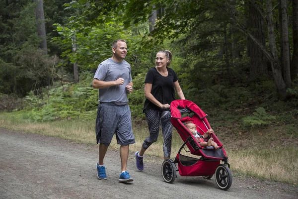 Casal Exercitando Jogging Juntos Empurrando Seu Bebê Carrinho — Fotografia de Stock