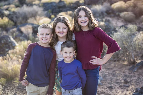 屋外で幸せな子供たちを笑顔の美しい肖像画 4人の兄弟がかわいい絵のために一緒に立っている 10代の女の子と3人の若い子供 — ストック写真