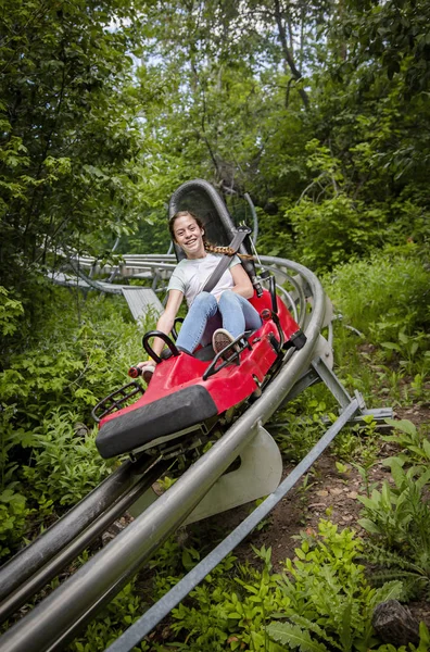 Glimlachend Tienermeisje Dat Bergafwaarts Rijdt Een Outdoor Achtbaan Een Warme — Stockfoto