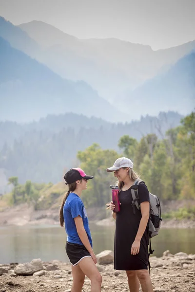 아름다운 어머니와 야외에서 등산을 합니다 산들이 보이는 곳에서 대화를 나누고 — 스톡 사진
