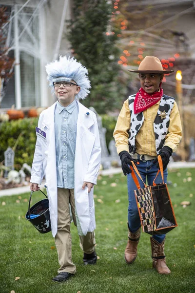 ハロウィンの衣装を着た2人の子供の写真がトリックになるか 装飾された近所で10月に屋外で治療する — ストック写真