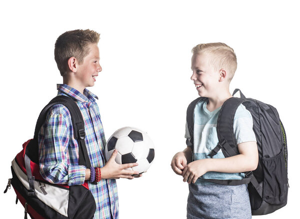 Two smiling boys playing together at school. Two friends talking together isolated on a white background