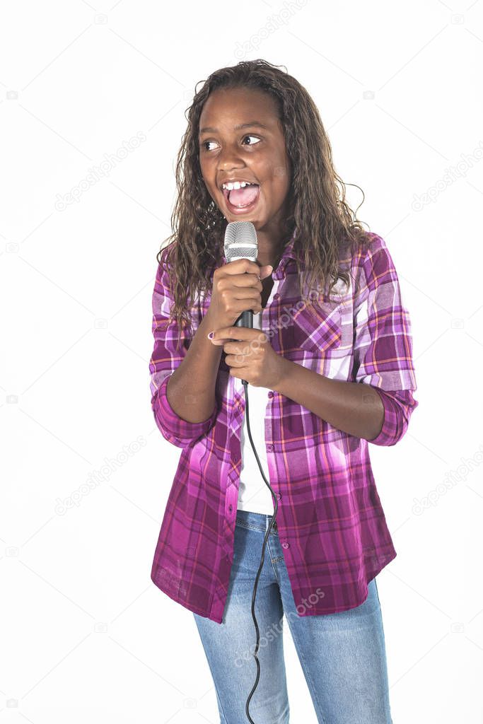 Talented young diverse singer singing into a microphone. Cute African American girl singing with energy and performing on stage. Isolated on a white background