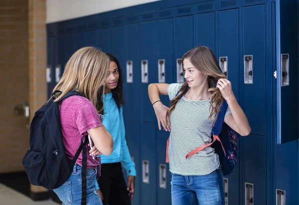 学校の廊下で3人の中学生が一緒に話している様子が撮影できました 女子校生の笑顔と楽しい一緒に学校で休憩中に — ストック写真