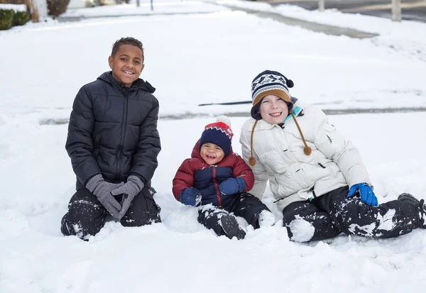 雪の中で一緒に遊んでいる3人のかわいい多様な男の子屋外 — ストック写真