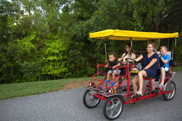 年轻快乐的家庭一起骑着一辆双人三轮车 与孩子们在户外共度暑假 — 图库照片